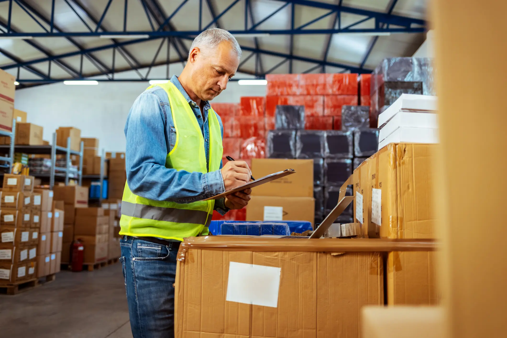 Stock clerk checking inventory in the warehouse of industrial factory